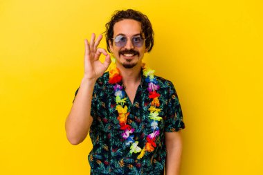 Beyaz bir erkek sarı arka planda izole edilmiş Hawaii kolyesi takıyor. Neşeli ve kendinden emin..