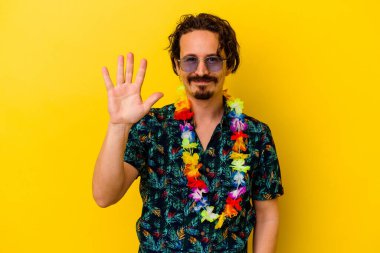 Sarı arka planda izole edilmiş Hawaii kolyesi takan beyaz bir adam gülümseyerek beş numarayı parmaklarıyla gösteriyor..