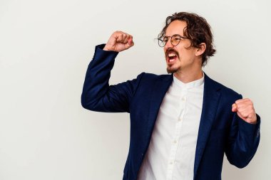 Genç iş adamı beyaz arka planda izole edilmiş zaferden sonra yumruğunu kaldırıyor, kazanan konsept.