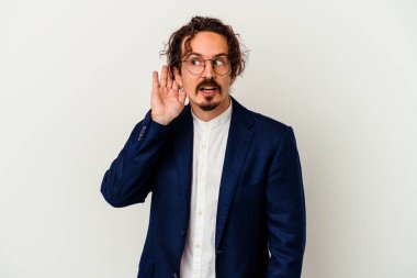 Genç iş adamı beyaz arka planda bir dedikoduyu dinlemeye çalışıyor..