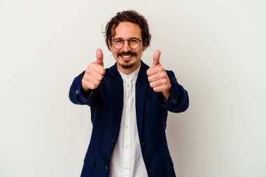 Genç iş adamı beyaz arka planda izole edilmiş, başparmakları havada, bir konuda tezahürat yapıyor, destek ve saygı kavramına sahip..