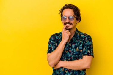 Sarı arka planda izole edilmiş yaz kıyafetleri giyen genç beyaz adam bir şeyin fotokopi odasına baktığını düşünerek rahatladı..