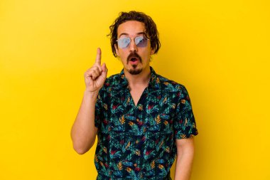 Sarı arka planda izole edilmiş yaz kıyafetleri giyen genç beyaz bir adamın harika bir fikri var, yaratıcılık kavramı..