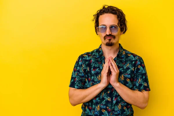 Sarı arka planda izole edilmiş yaz kıyafetleri giyen genç beyaz bir adam bir fikir üretiyor..