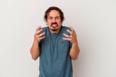 Beyaz arka planda izole edilmiş genç beyaz adam gergin elleriyle çığlık atıyor..