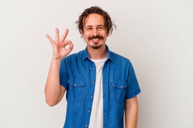 Beyaz arka planda izole edilmiş genç beyaz bir adam neşeli ve kendinden emin..