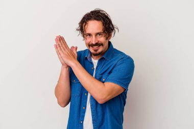 Beyaz arka planda izole olmuş genç beyaz bir adam enerjik ve rahat hissediyor, ellerini ovuşturuyor..