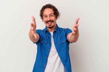 Beyaz arka planda izole edilmiş genç beyaz adam kameraya sarıldığı için kendinden emin hissediyor..