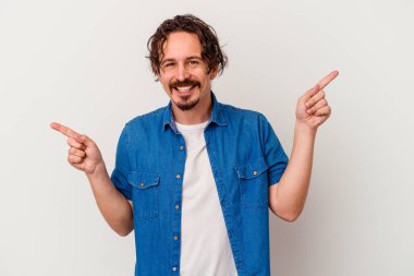 Beyaz arka planda izole edilmiş genç beyaz bir adam farklı kopya alanlarını gösteriyor, birini seçiyor, parmaklarıyla gösteriyor..