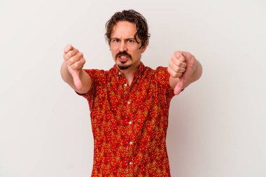 Beyaz arka planda izole edilmiş genç beyaz bir adam baş parmağını aşağı gösteriyor ve hoşlanmadığını ifade ediyor..