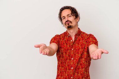 Beyaz arka planda izole edilmiş genç beyaz bir adam dudaklarını katlıyor ve hava öpücüğü vermek için avuç içleri tutuyor..