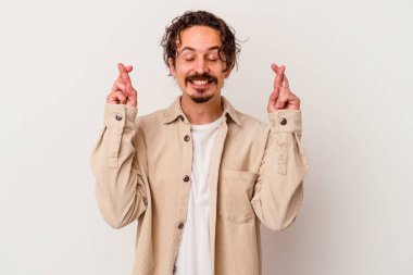 Beyaz arka planda izole genç beyaz adam şans dilemek için şans diliyor.