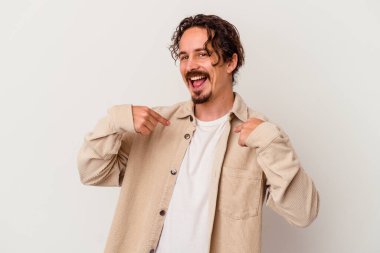 Beyaz arka planda izole edilmiş genç beyaz bir adam parmağını göstererek şaşırdı, geniş bir gülümsemeyle..