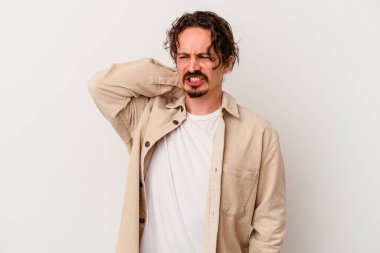 Beyaz arka planda izole edilmiş genç beyaz bir adam yorgun ve uykulu bir şekilde elini başının üstünde tutuyor..