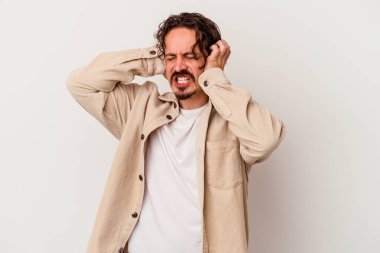 Beyaz arka planda izole edilmiş genç beyaz bir adam kulaklarını elleriyle kapatıyor..