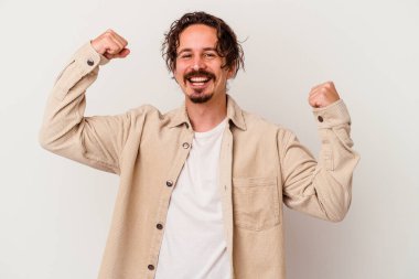 Beyaz arka planda izole edilmiş genç beyaz adam tasasız ve heyecanlı bir şekilde tezahürat yapıyor. Zafer konsepti.