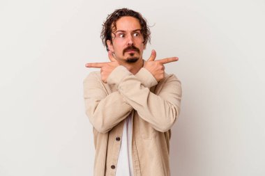 Beyaz arka plan noktalarında izole genç beyaz adam, iki seçenek arasında seçim yapmaya çalışıyor.