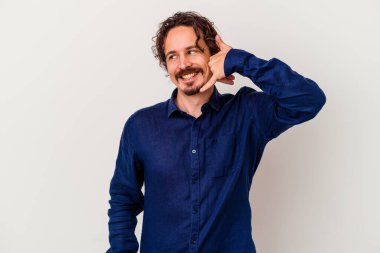 Beyaz arka planda izole edilmiş genç beyaz bir adam parmakları olan bir cep telefonu hareketi gösteriyor..