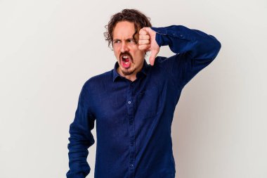 Beyaz arka planda izole edilmiş genç beyaz bir adam baş parmağını aşağı gösteriyor ve hoşlanmadığını ifade ediyor..