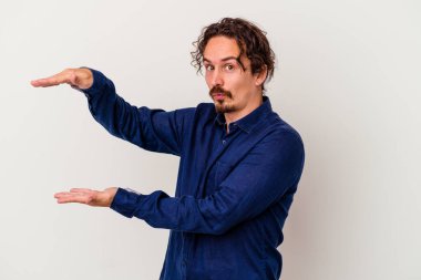 Beyaz arka planda izole edilmiş beyaz bir adam iki eliyle bir şey tutuyor..