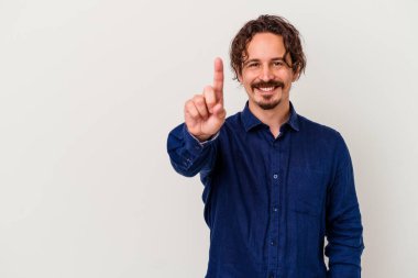 Beyaz arka planda izole edilmiş beyaz tenli genç bir adam bir numarayı parmağıyla gösteriyor..