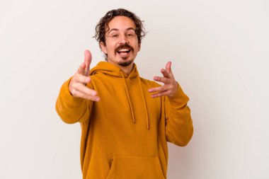 Beyaz arka planda izole edilmiş genç beyaz adam kameraya sarıldığı için kendinden emin hissediyor..