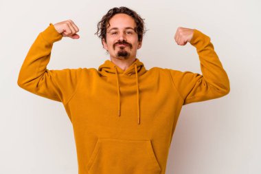 Beyaz arka planda izole edilmiş genç beyaz bir adam güçlü bir hareket gösteriyor, kollarıyla, kadınsı gücün sembolü.