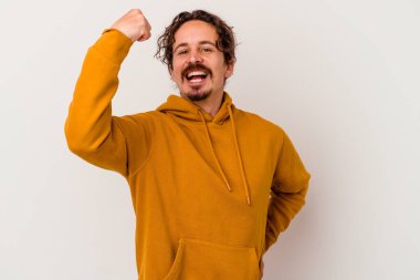 Beyaz arka planda izole edilmiş genç beyaz adam tasasız ve heyecanlı bir şekilde tezahürat yapıyor. Zafer konsepti.