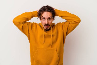 Beyaz arka planda izole olmuş genç beyaz bir adam çığlık atıyor, çok heyecanlı, tutkulu, bir şeyden memnun..