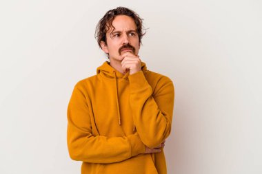 Beyaz arka planda soyutlanmış genç beyaz bir adam düşünüyor ve yukarı bakıyor, yansıtıyor, düşünüyor, hayal kuruyor..