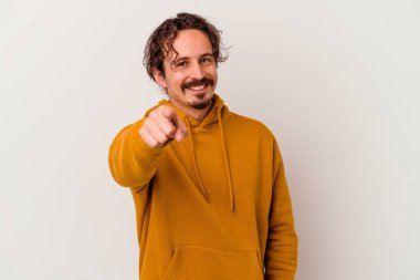 Beyaz arka planda izole edilmiş genç beyaz adam parmaklarıyla ön tarafı işaret ediyor..