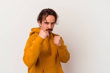 Beyaz arka planda izole olmuş genç beyaz bir adam bir tartışma yüzünden yumruk atıyor, sinirleniyor, kavga ediyor, boks yapıyor..