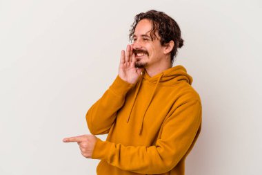 Beyaz arka planda izole edilmiş genç beyaz bir adam bir dedikodu söylüyor, bir haber sunuyor..