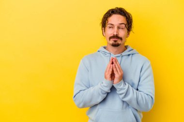 Kafkasyalı genç bir adam sarı arka planda izole edildi. Aklında bir plan oluşturdu..