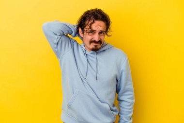 Sarı arka planda izole edilmiş genç beyaz adam sabit yaşam tarzından dolayı boyun ağrısından muzdarip..