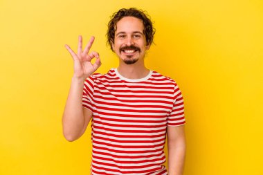 Genç beyaz adam sarı arka planda izole edilmiş neşeli ve kendinden emin..