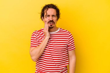 Sarı arka planda izole genç beyaz adam güçlü bir diş ağrısı, azıdişi ağrısı var..