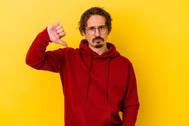 Sarı arka planda izole edilmiş, hoşlanmadığı bir hareket gösteren beyaz bir genç. Anlaşmazlık konsepti.