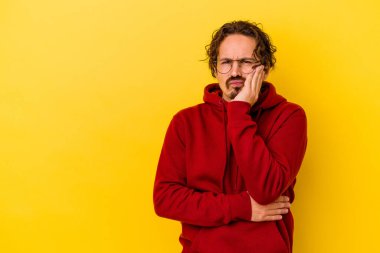 Sarı arka planda izole edilmiş genç, üzgün ve dalgın hisseden, kopyalama alanına bakan beyaz bir adam..