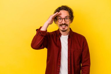 Sarı arka planda izole edilmiş genç beyaz adam yüksek sesle bağırıyor, gözleri açık ve elleri gergin tutuyor..