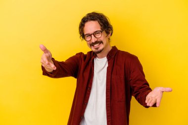 Sarı arka planda izole edilmiş beyaz bir genç hoş bir yüz ifadesi sergiliyor..