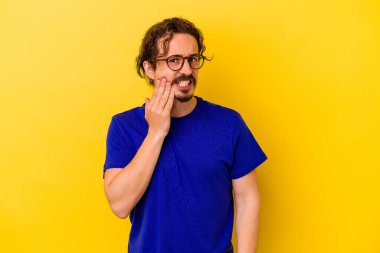 Sarı arka planda izole genç beyaz adam güçlü bir diş ağrısı, azıdişi ağrısı var..