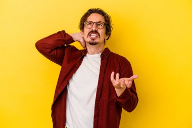 Sarı arka planda izole edilmiş genç beyaz adam öfkeyle bağırıyor..