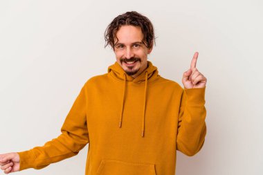 Beyaz arka planda izole edilmiş genç beyaz bir adam farklı kopya alanlarını gösteriyor, birini seçiyor, parmaklarıyla gösteriyor..