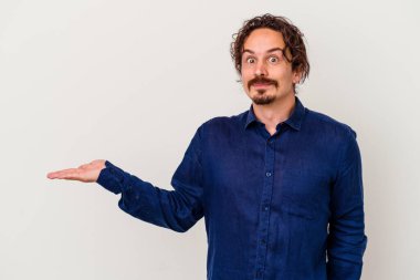 Beyaz arka planda izole edilmiş genç beyaz bir adam bir palmiye üzerinde fotokopi alanı gösteriyor ve belinde başka bir el tutuyor..