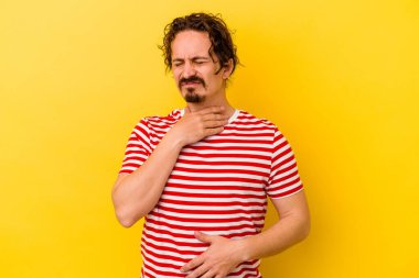 Sarı arka planda izole edilmiş genç beyaz bir adam virüs veya enfeksiyon yüzünden boğazında ağrı hissediyor..