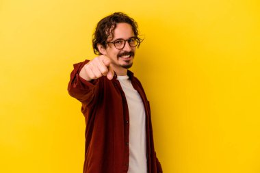 Sarı arka planda izole edilmiş genç beyaz adam öne bakan neşeli gülücükler.