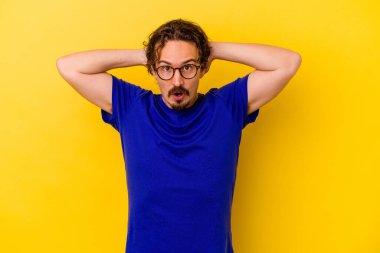 Sarı arka planda izole edilmiş genç beyaz bir adam çığlık atıyor, çok heyecanlı, tutkulu, bir şeyden memnun..