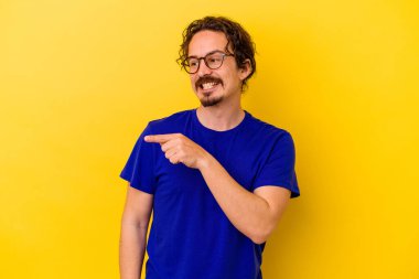 Sarı arka planda izole edilmiş genç beyaz adam gülümseyen, neşeli ve keyifli görünüyor..