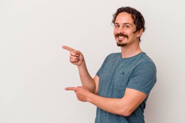 Beyaz arka planda izole edilmiş genç beyaz bir adam işaret parmağıyla işaret ettiği için heyecanlı..